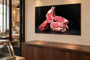 Mise en situation illustrative d’un tableau de pièces de bœuf sur le mur d’une boucherie.
